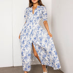 Woman wearing a blue floral dress against a white wall