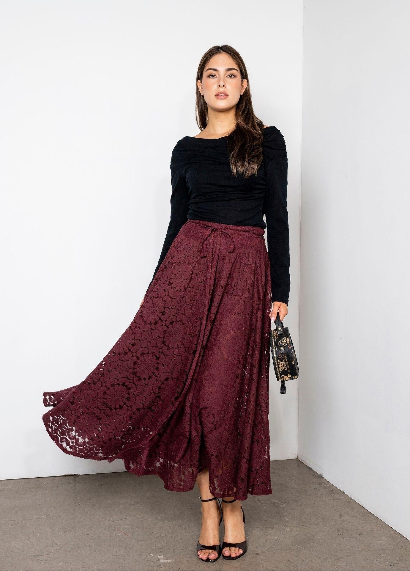 Astrid Skirt Vintage Wine in a full length front view, the wine red lace midi skirt styled with a black top, black heels and a small handbag on a concrete floor.