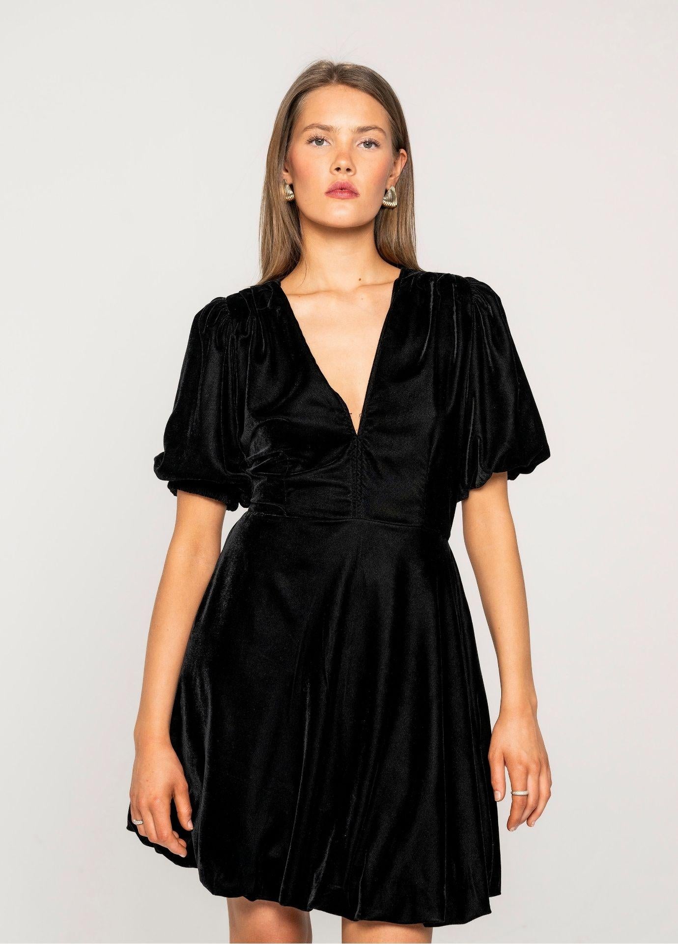 Blake Dress Velvet Black in a close studio view, showing the V-neckline, the voluminous puff sleeves and the soft sheen of the black velvet.