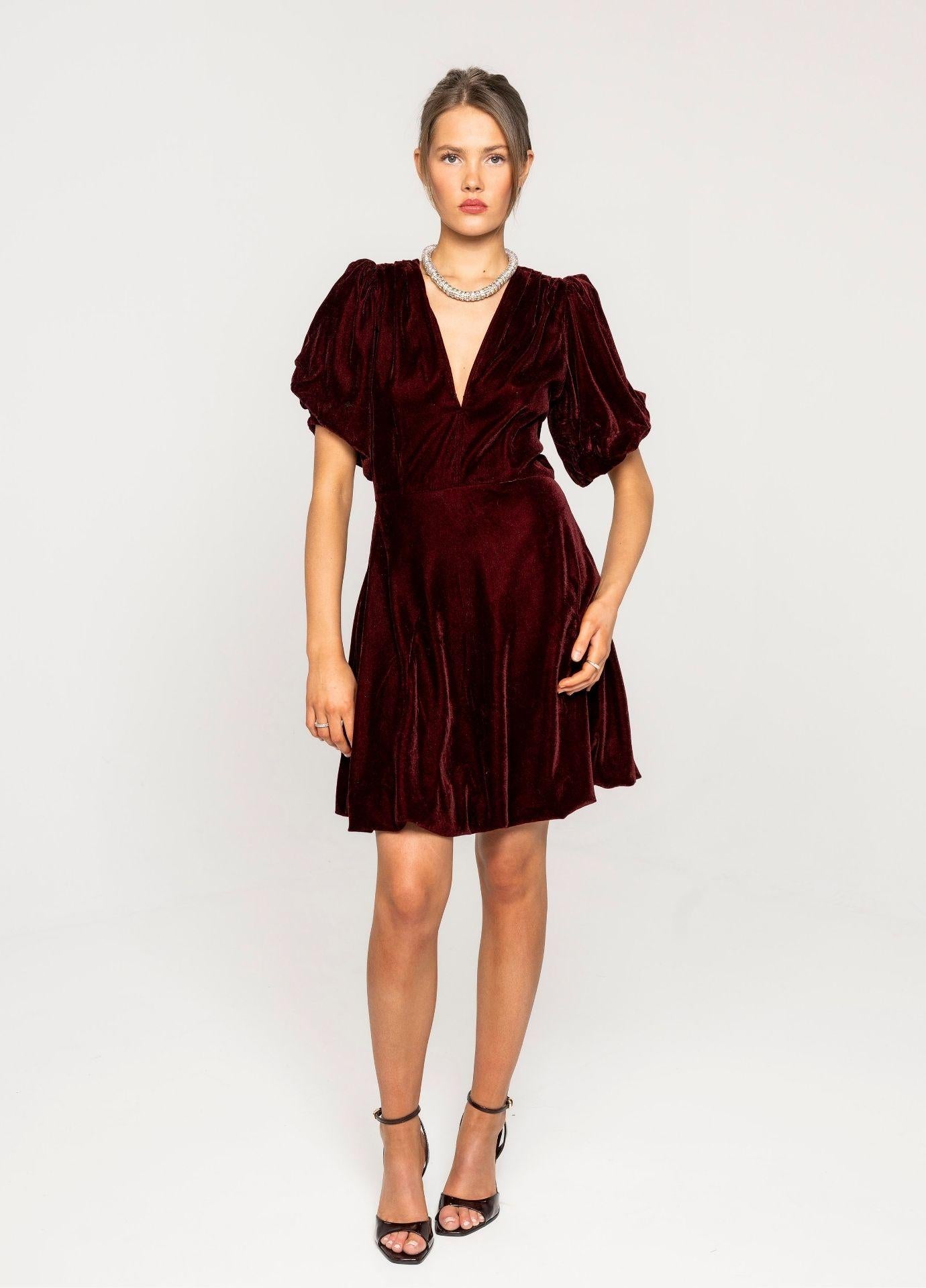 Blake Dress Velvet Bordeaux in a full length studio view, showing the balloon skirt and the short puff sleeves with black strappy heels against a light grey background.