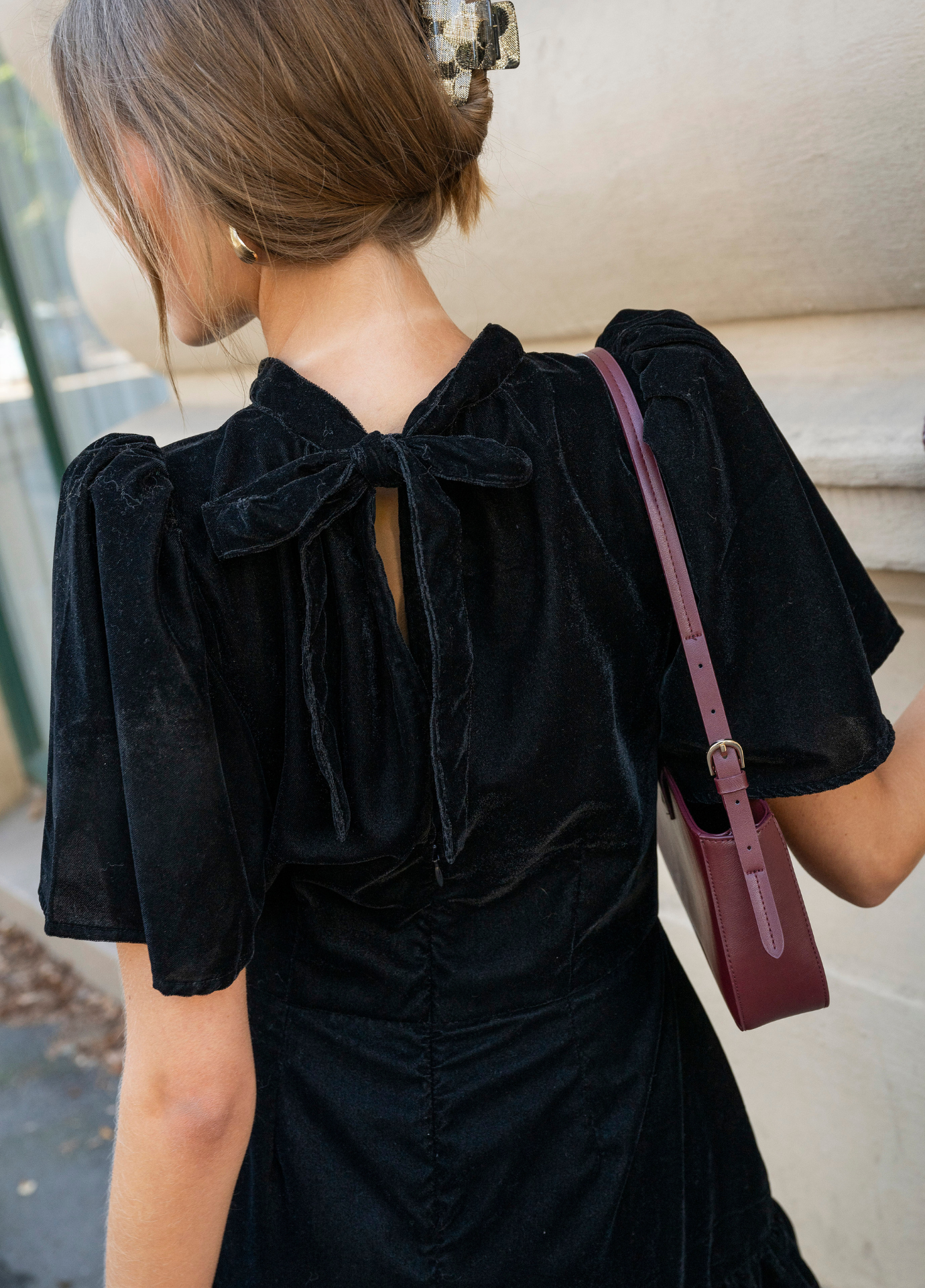 Jolie Dress Velvet Black from behind, showing the bow tied at the back of the neckline and a small keyhole opening.