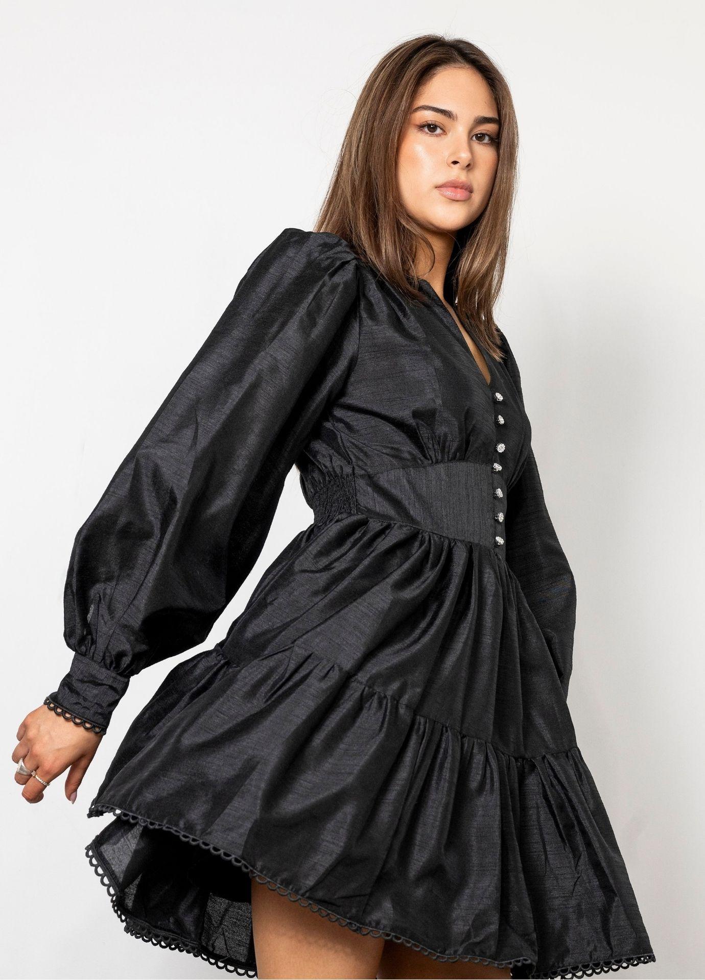 Primrose Dress Evening Black in a close view in motion, showing the high collar, the balloon sleeves and the lace trimmed hem of the tiered skirt.