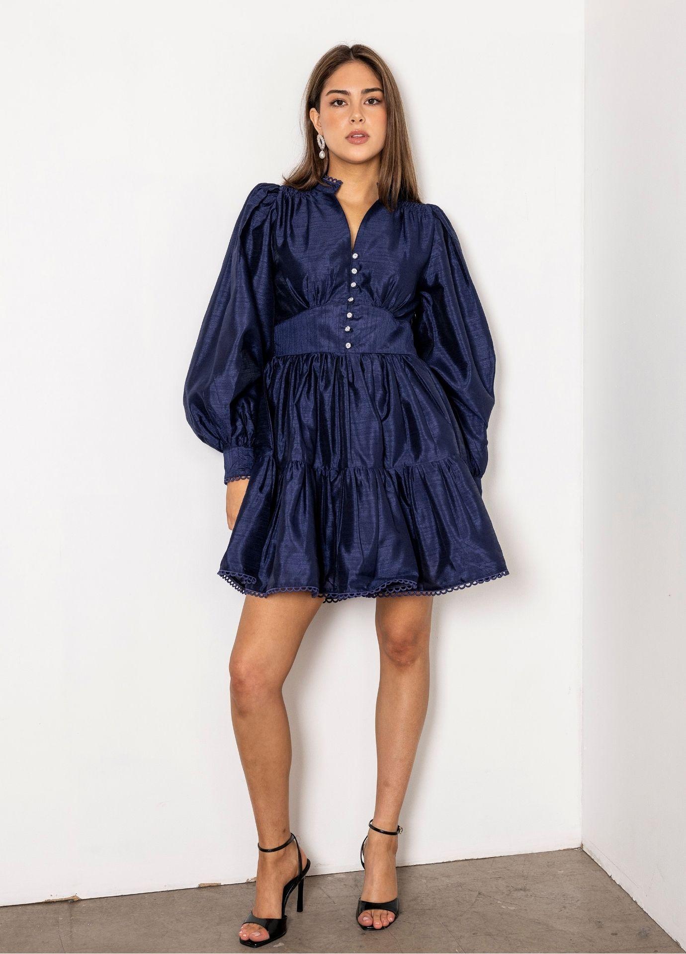 Primrose Dress Evening Blue in a full length front view, showing the wide waistband and the full tiered skirt, with black strappy heels.