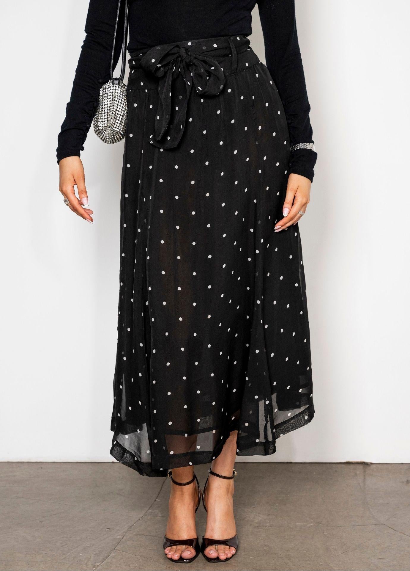 Vanja Skirt Black Pearl in a close view of the tie belt and the pleated waist, with the sheer dotted fabric falling over a shorter lining.