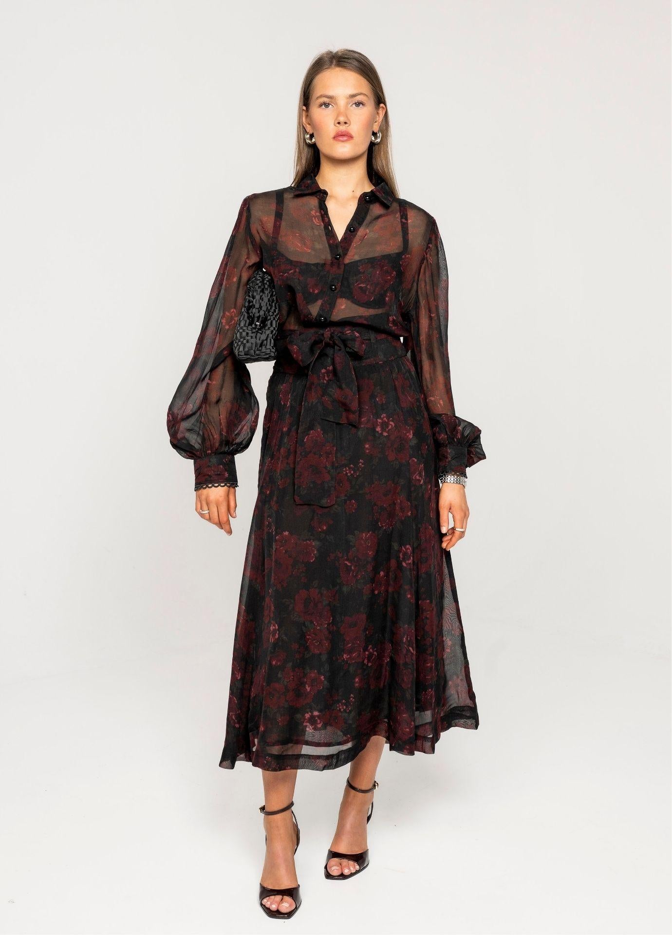 Vanja Skirt Black Romance in a full length front view, showing the tie belt at the waist and the full, flowy skirt in sheer floral fabric.